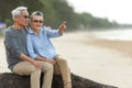 Asian Lifestyle senior couple pointing and hug see beach happy in love romantic and relax time Royalty Free Stock Photo